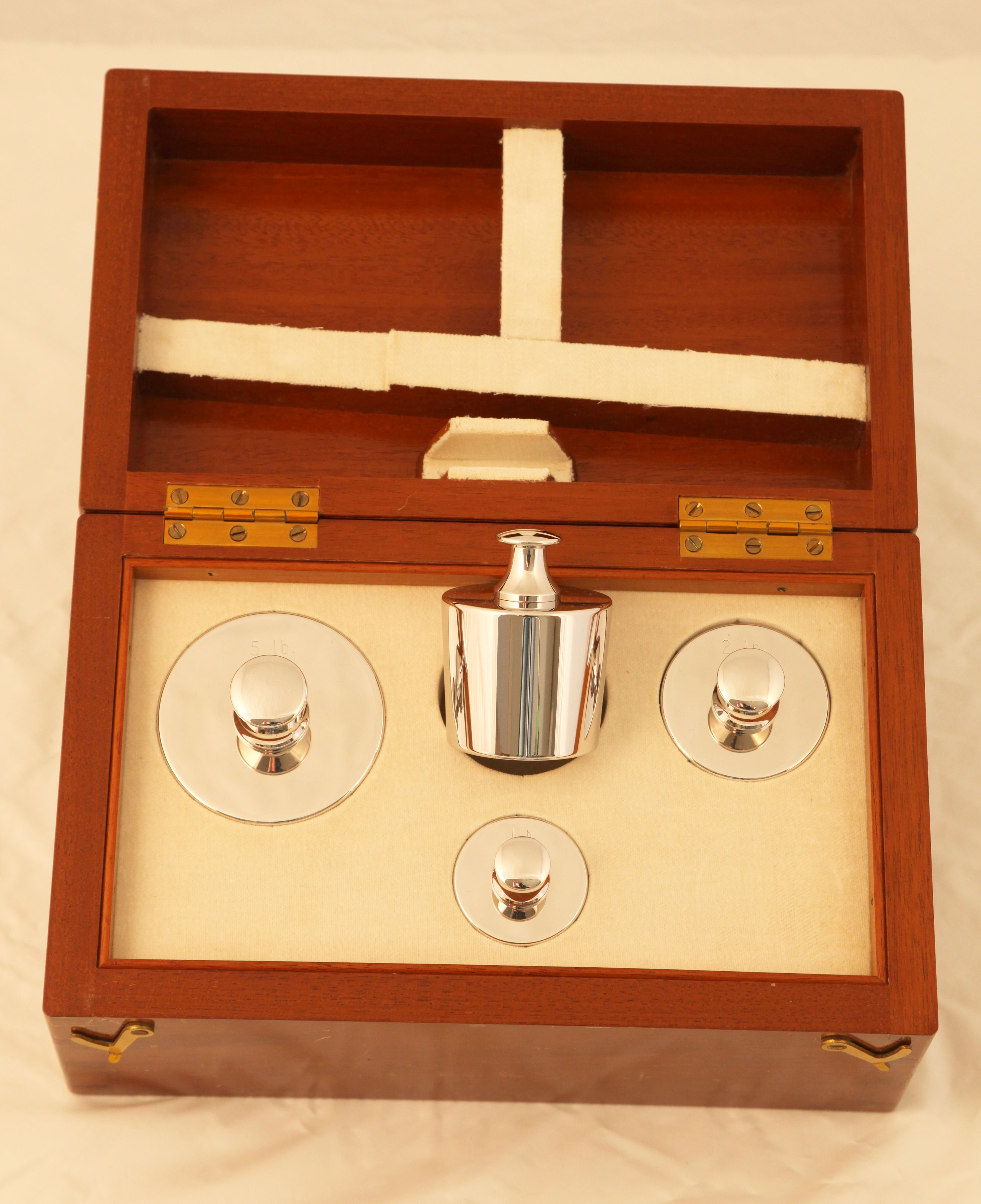 An imperial weight set, 1 lb, 2lb, 3 lb and 5 lb in a nice mahogany box with white cloth lining.